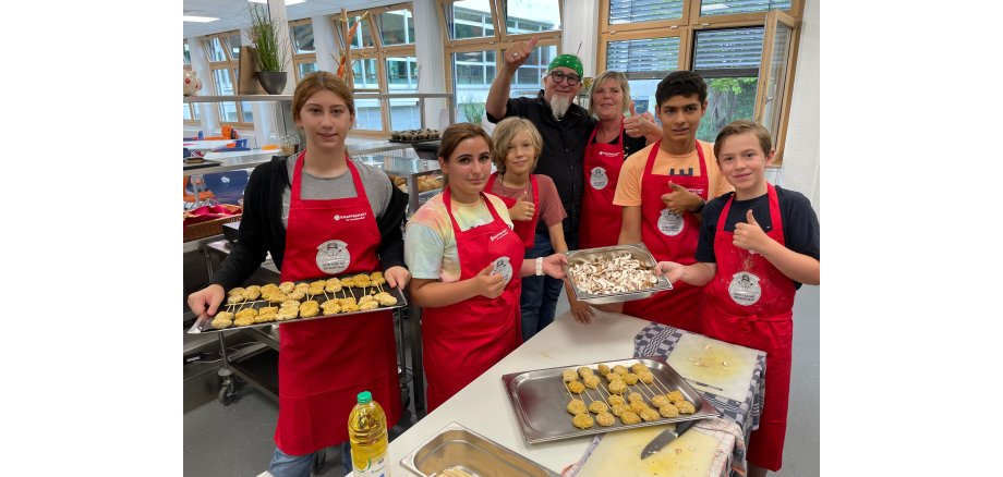 Gesund Kochen macht Spaß - dafür Daumen hoch! Mit dabei waren u.a.v.l.n.r.: Melissa, Nora, Robin, Sternekoch Stefan Marquard, Mensa "Küchen-Fee" Birgit Bartz, Leo und Lukas  