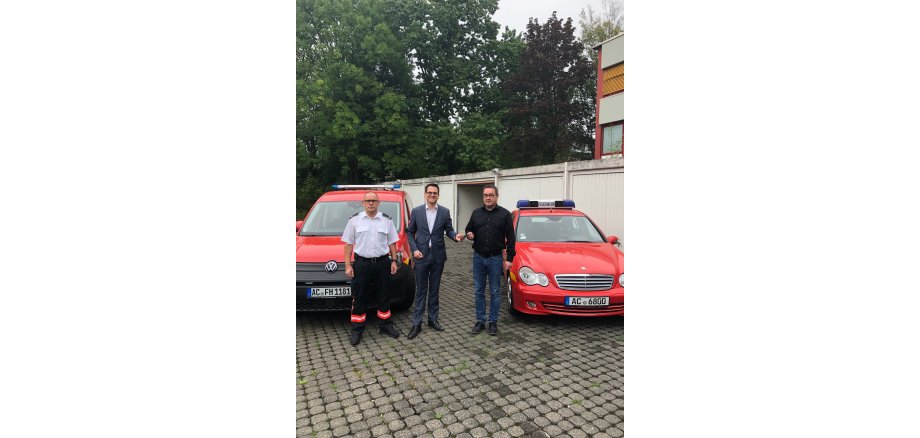 Achim Schwark (Leiter Feuerwehr), Dr. Benjamin Fadavian (Bürgermeister) und Michael Schumacher (Rathauswache) bei der symbolischen Schlüsselübergabe (v.l.)).