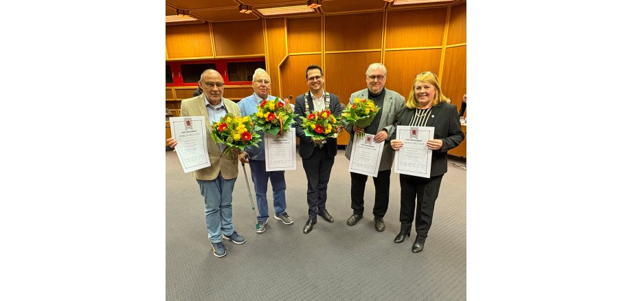 Das Bild zeigt den Bürgermeister mit den Geehrten im großen Sitzungssaal während der Ratssitzung. Dies sind: Wolfgang Rüland, Manfred Grouls, Bürgermeister Dr. Benjamin Fadavian, Hartmut Prast und Marie-Theres Sobczyk (v.l.n.r.)