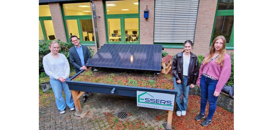 Bild der Balkonsolaranlage im Gymnasium mit Schülerin Pauline Hirschhausen, Bürgermeister Dr. Benjamin Fadavian, Schülerin Venus Masoudi und Fabienne Heinrichs von der Klima- und Umweltschutzabteilung der Stadt Herzogenrath (v.l.n.r.)