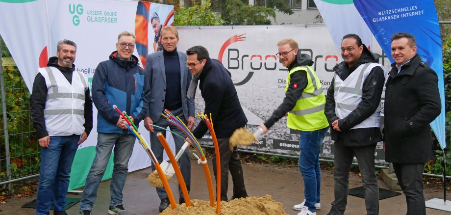 Die Beteiligten beim Spatenstich in Kohlscheid. Von links nach rechts sind dies: Aydogan Toptas, Construction Quality Specialist (CQS) bei UGG; Gerrit Heidenreich, zuständiger Sachbearbeiter im Tiefbauamt der Stadt Herzogenrath; Markus Terodde, Dezernent für Bildung, Jugend und Strukturentwicklung bei der StädteRegion Aachen; Dr. Benjamin Fadavian, Bürgermeister der Stadt Herzogenrath; Jan-Alexander Scheideler, Head of FTTH Rollout Management bei UGG; Reza Alishirazi, Regional Deployment Manager bei UGG; Johann Bruckner, Geschäftsführer der Broos Project GmbH