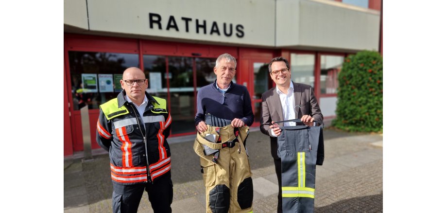 Gruppenbild mit Achim Schwark, René Günther und Dr. Benjamin Fadavian (v.l.n.r.), die die dank der Förderung der Provinzial neu angeschafften Feuerwehrhosen präsentieren